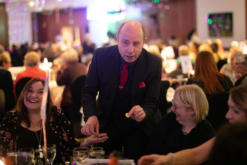 Mark performing table-side magic for seated wedding guests